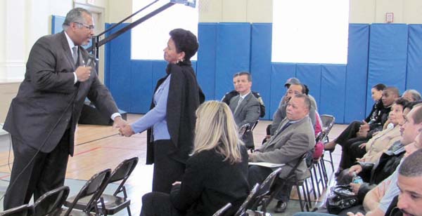 ATF Chief: Isaura Mendes, mother of two murdered sons, reaches out to Guy Thomas, head of Boston’s ATF office, at Sunday afternoon’s meeting at St. Peter’s Teen Center. 	Photo by Stephen Kurkjian