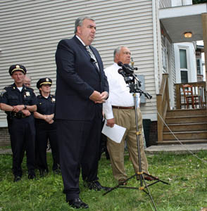 Police Commissioner Edward Davis and Mayor Thomas Menino spoke outside 102 Blue Hill Ave. on July 5. The house was the subject of 105 service calls in a year.