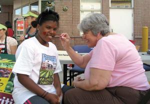 The Bowdoin Geneva Farmer’s Market — which opens for the season today— is one of nine across the city that will offer fresh-caught fish along with produce and other items. Above, face-painting was one of the attractions at the Bowdoin Geneva market during a block party last year. Photo courtesy Bowdoin Street Health Center