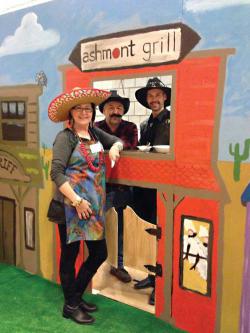 The Ashmont Grill booth at Sunday’s Dot Day Chili Cook-off was built and painted in cooperation with DotArt. Pictured from left: Millie Rooney, Chris Douglass and Nuno Alves.	Photo by Ed Geary