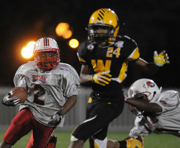 Eagles in action at Disney tournament: The Dorchester squad — in white—fell to the Liberty City Warriors in first-round game on Sunday. Photo by Gerardo Mora for Pop Warner