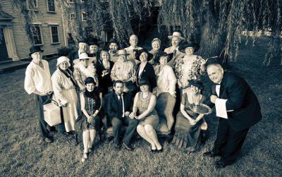 The Dorchester Historical Society is hosting a “Dinner at Willow Court” tomorrow night (Sept. 26) at 6 o’clock at the society’s headquarters at 195 Boston St. The DHS plans a festive evening to recall the style and elegance of earlier times: cocktails, a seated dinner, and a live auction. Period attire encouraged: Victorian, Edwardian, Roaring Twenties, upstairs or downstairs.  Proceeds to benefit the DHS Building Restoration fund. Board members and volunteers who dressed in Downton Abbey style for this photo include: Back row, from left: Richard O’Mara, Robert Severy, Gene Gorman, Kit Binns, Earl Taylor, Jeff Gonyeau. Middle row: Bill Loesch, Karen McNutt, Peggy Mullen, Emy Thomas, Anne Schmalz, Vicki Rugo, Terry Dolan, Rosanne Foley. Seated: Joyce Ellis, Joe Bagley, Jen Poulsen, Lianne Ames, and Paul Delorey.   Photo courtesy DHS, © Mike Ritter 2014