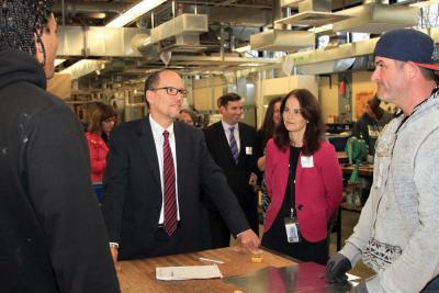 Thomas Perez, US Secretary of Labor, center, spoke with third-year sheet metal apprentices Sean Bettencourt, left, and James Dearden, right, as Rachel Kaprielian, Massachusetts Secretary of Labor and Workforce Development listens during a Monday visit to the Sheet Metal Workers Local No. 17 in Lower Mills. 	Tiffannie Bond photo