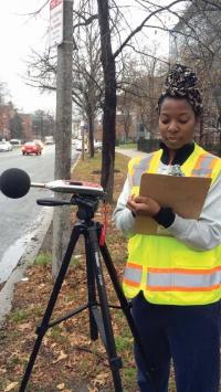 Erica Walker, a doctoral candidate with the Harvard T.H. Chan School of Public Health, measures noise outside the Longwood Medical area. Emily Dubreuil photo