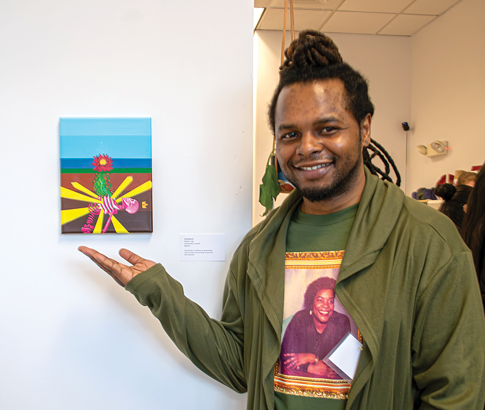 Photo 4_Sherwin.Long stands next to his work.png
