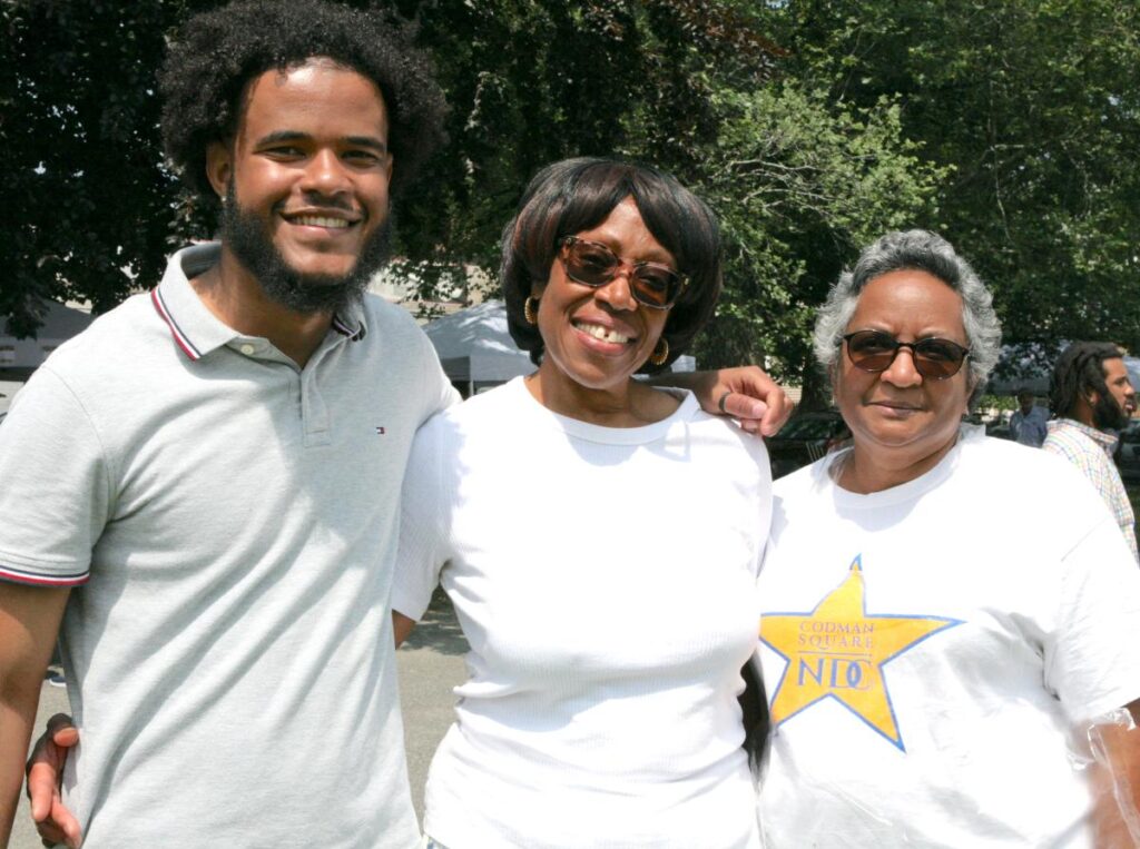Three people smile and look at the camera.
