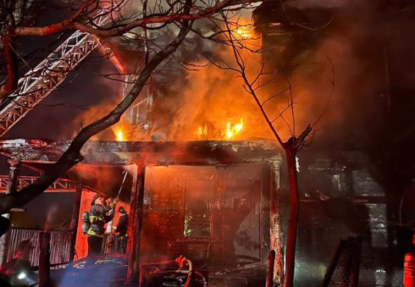 House ablaze on Draper Street, with firefighters on what's left of front porch